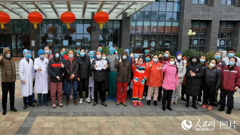 出院患者与医护人员为战胜病毒点赞。韩基琛 摄